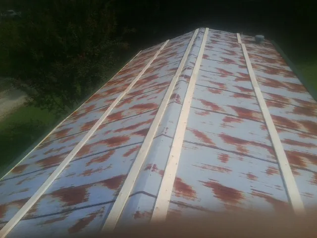 Rusted metal roof panels with new wood purlins before replacement — Storm Damage Roof Repair in Fords by Roofing Brothers